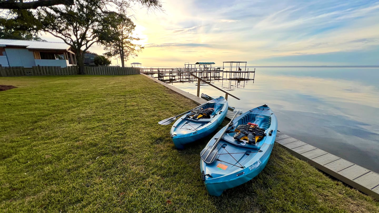 Kayaks on the bay at sunset behind Cozy Bay Front in Gulf Breeze, Florida